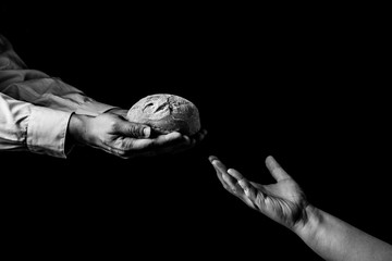 Man giving Bread to person in need. Helping Hand Concept. Black and white - obrazy, fototapety, plakaty