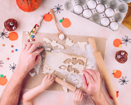 Halloween cookies making by father and kid hands