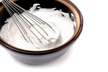 Whipped Cream with a Whisk on a White Background