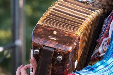 Close up of accordion player playing at Klezmer Jewish music concert in Regent's Park in London UK