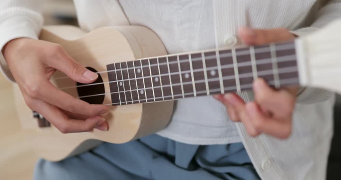 Woman play a song on ukulele