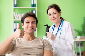 Female doctor checking patient's ear during medical examination 