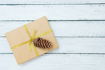 Christmas gift in a box on a white wooden background. Close-up.