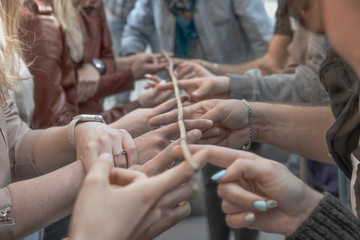 Obraz na płótnie Canvas conceptual image of teamwork, a group of people holding sticks holding a bamboo branch.