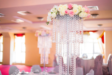 flower arrangement, crystal, glass candles decorate banquet hall
