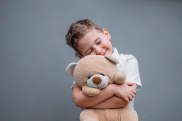 Fotobehang Safety concept. The boy is holding teddy bear © TetianaRUD