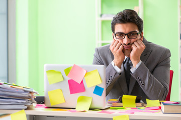 Businessman unhappy with many conflicting priorities sitting in 