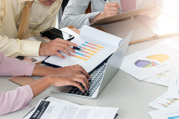Group of business people conference and using laptop computer for report record during the meeting, Side view of woman hand typing on laptop keyboard in workplace, Teamwork concept.