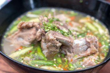 Hot and spicy pork spare rib soup with tamarind and Thai herbs in bowl, Tom yum, Hot and sour soup.