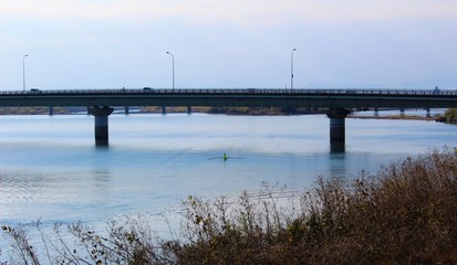 Fototapeta na wymiar A bridge over calm Kuma River in winter scenery