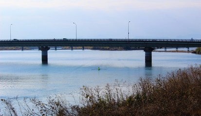 Fototapeta premium A bridge over calm Kuma River in winter scenery