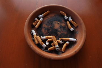 cigarette butts and ashes in ashtray