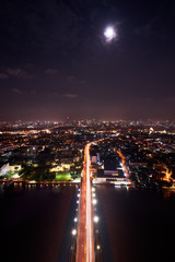 Fototapeta na wymiar scenic of night cityscape with light tail of speed line on bridge