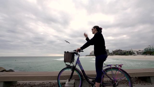 Cyclist Woman bicycle walk brazilian sea shore health fitness activity beach Rio de janeiro, Brazil