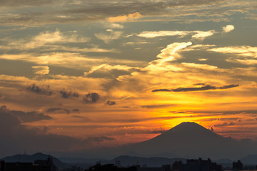 Golden sun setting behind the peak of mount Fuji