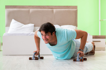 Young man in pajamas doing morning exercises 