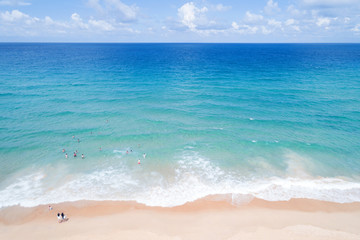 Fototapeta na wymiar People enjoy swimming in tropical sea and wave crashing on sandy shore at karon beach in phuket thailand,aerial view drone shot.