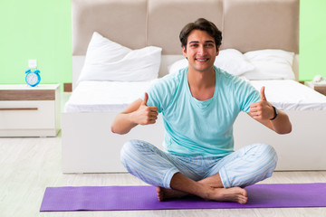 Young man in pajamas doing morning exercises 