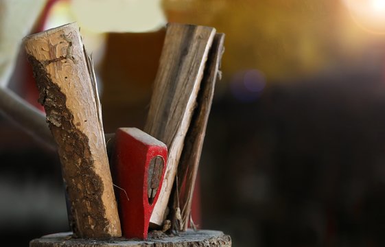 Axe splitting wood in two on chopping block