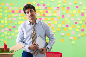 Man collecting his stuff after redundancy in the office with man