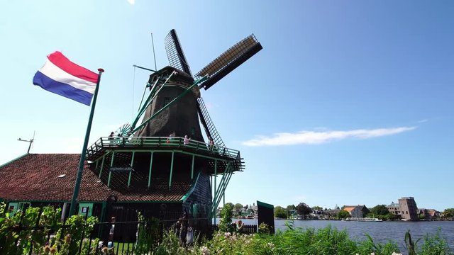 Tourists taking pictures of traditional historic Windmills at the Zaanse Schans near Amsterdam, Holland