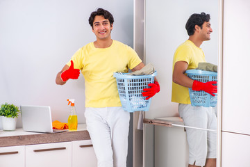 Young handsome man cleaning in the bedroom