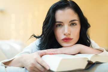 Young woman with a book in her home