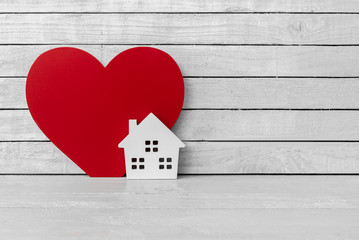 Home Shaped with Red Heart Shaped on white wood over white wood background © pachaileknettip