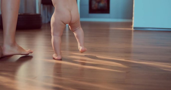 Kid Takes The First Steps With His Mother. Baby's Naked Body