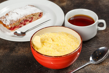 Wheat porridge in bowl, cake, and tea