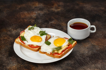 Sandwich with cheese, bacon, tomato and fried egg on plate