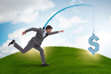 Businessman chasing money on fishing rod