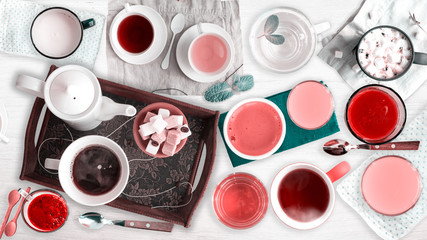 Set of different cold drinks and hot drinks - juices, coffee, tea, milk, mint water - cups and mugs served on white wooden table. Closeup. Top view.