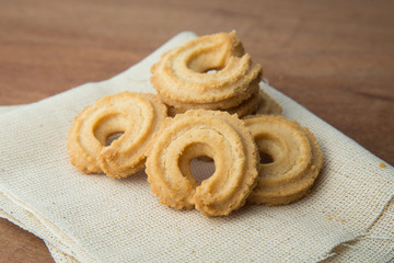 Butter cookies on white linen on wooden table.