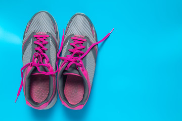 Sport flat lay pink shoes on blue background with copyspace for your text. Concept healthy lifestyle and diet.