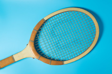 Tennis racket on blue background. Sport equipment. Flat lay.