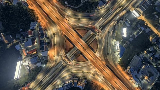 timelapse of night city traffic on 4-way stop street intersection circle roundabout in bangkok, thailand. 4K UHD horizontal aerial top view.