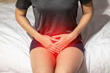 woman have bladder or uti pain sitting on bed in bedroom after wake up feeling so...
