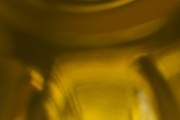Blurred macrophotography. The bottom of the plastic bottle,  with yellow vegetable oil.Site about kitchen, photography, art,abstraction,food industry.