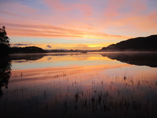 Fototapeta na wymiar a sunrise over the mountains lake