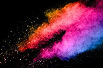 Abstract multicolored powder explosion on black background. Color dust particle splattered on background.