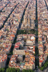 Fototapeta premium Barcelona z lotu ptaka, dzielnica mieszkaniowa Eixample i Sagrada Familia, Hiszpania. Typowa miejska siatka