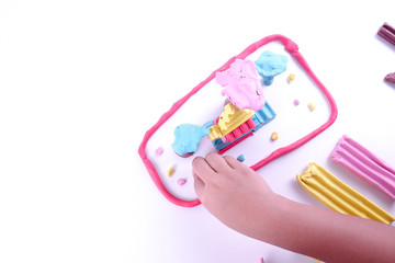 Child hands playing with colorful clay.