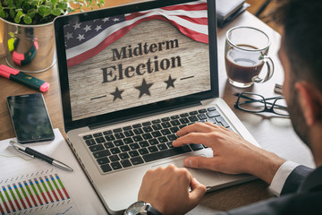 Businessman with a US of America midterm elections picture onscreen