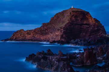 Rocky coast and lighthouse at night in Porto Moniz. Madeira. Portugal