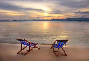 Two sunbed on topical beach ,Beach chairs on sand ,view sunset