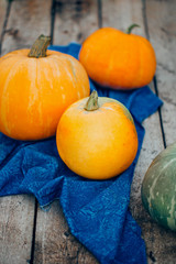 A large orange pumpkin on the blue towel on wooden background. autumn