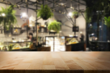 Selected focus empty brown wooden table and Coffee shop or restaurent blur background with bokeh image. for your photomontage or product display