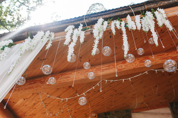 Original wedding floral decoration in the form of mini-vases and bouquets of flowers hanging from the ceiling