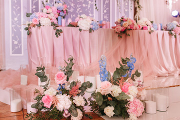 Richly decorated with flowers and fabrics reception for a wedding Banquet. Pastel pink colors